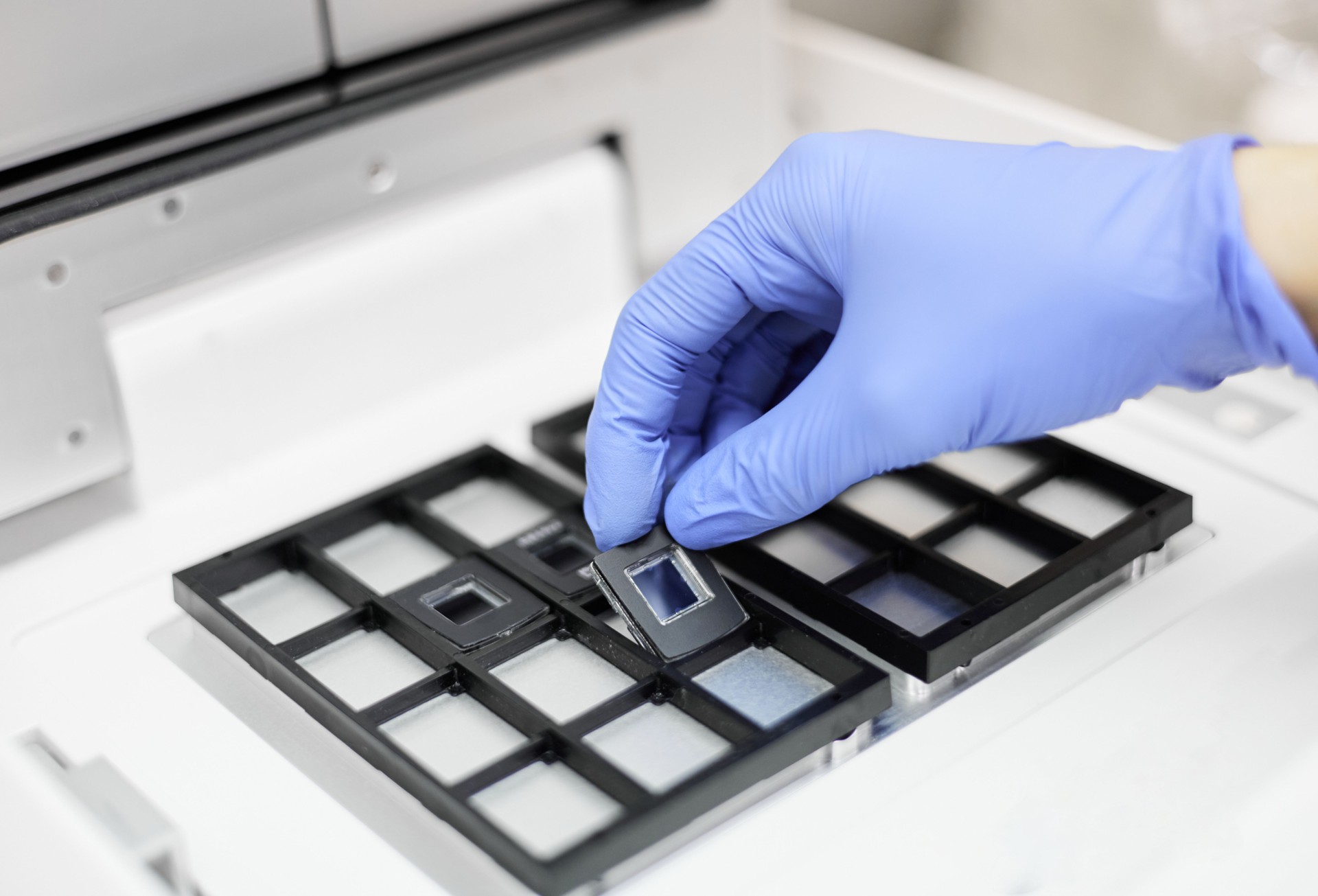 A researcher putting a chip in the PCR system for digital PCR performance
